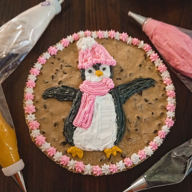 A round cookie cake with a penguin design.